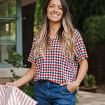 Model standing outdoors wearing Women's Relaxed Fit V-Neck in Patriotic Gingham over denim pants