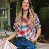 Model standing outdoors wearing Women's Relaxed Fit V-Neck in Patriotic Gingham over denim pants