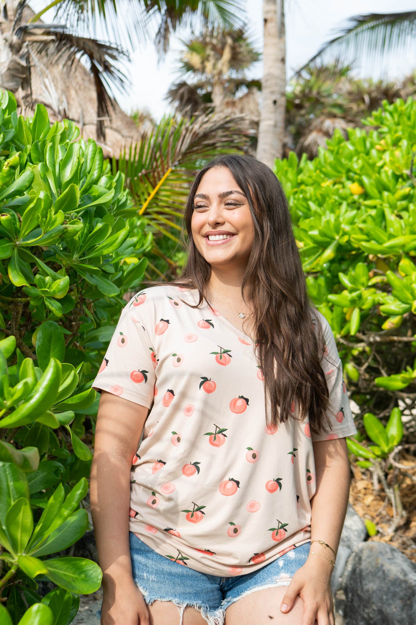 Model wearing the Women’s Relaxed Fit V-Neck in Peach paired with jean shorts