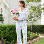 Woman outside looking over holding a vase of flowers wearing long sleeve  pajamas and pants in Peony on Breeze print. ---1605 1