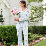 Woman outside looking over holding a vase of flowers wearing long sleeve  pajamas and pants in Peony on Breeze print. ---1605 1