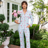 Woman outside holding a vase of flowers with the other hand in her pocket wearing long sleeve pajamas and pants in Peony on Breeze print. ---1605 3