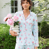 Woman outside soft smiling holding a vase of flowers in long sleeve pajamas and pants in Peony on Breeze print. ---PJ 4