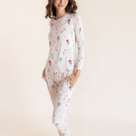 A woman modeling a two-piece long-sleeve pajama set with a colorful pickleball print on a light cream background, set against a solid warm beige studio backdrop.
::: Model is 5'9.5" wearing size XS ///