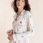 A woman wearing a long-sleeve pajama shirt with a colorful pickleball pattern on a cream background, posed against a solid light beige backdrop.
---PJ 4
