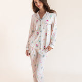 A woman modeling a matching long-sleeve pajama set with a white base and a colorful pickleball print against a plain cream studio background.
::: Model is 5'9.5" wearing size XS ///
---1605 3