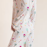 A person wearing a matching long-sleeve pajama set with a playful pickleball  print, shown from the back against a plain beige studio background.