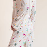 A person wearing a matching long-sleeve pajama set with a playful pickleball  print, shown from the back against a plain beige studio background.