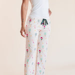 A woman modeling white pajama pants with a colorful pickleball pattern, paired with a white tank top, against a solid beige background.
::: Model is 5'9"" wearing size S ///