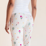 White leggings with a colorful pickleball racket pattern, worn by a model from the back against a light beige background.