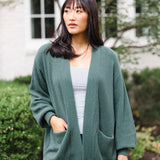 Woman looking to the side with her hand in her cardigan pocked in the color pine
::: Model is 5'9" wearing size S ///