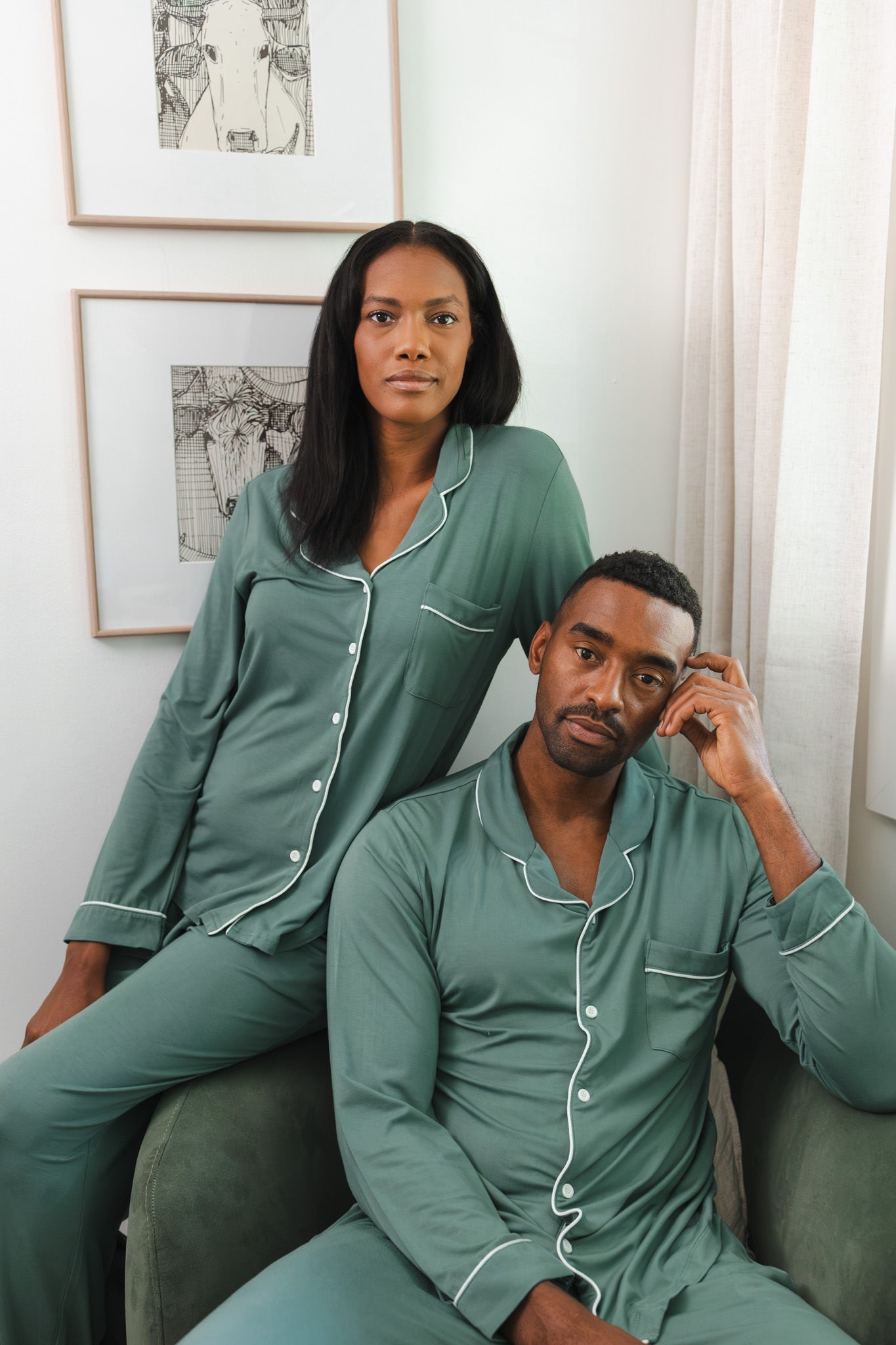 A couple wearing matching dark green button up pajamas 