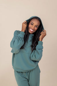 Woman modeling a pine green hoodie and matching sweatpant