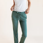 Model wearing Women's Lounge Pants in Pine under white camisole on a beige background
::: Model is 5'9.5" wearing size XS ///