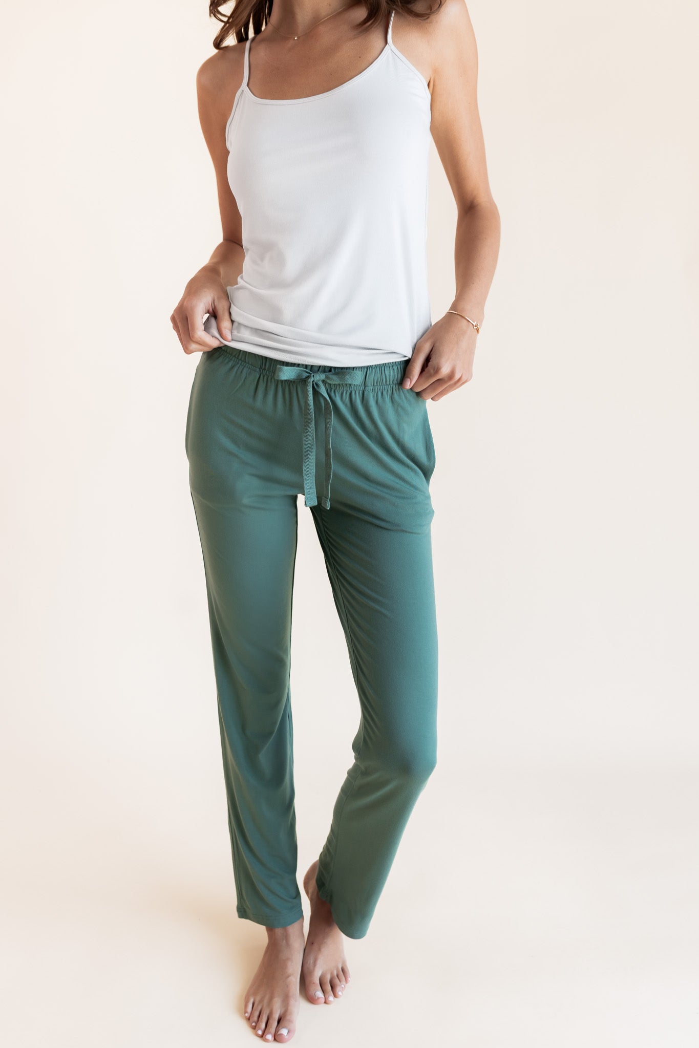 Model wearing Women's Lounge Pants in Pine under white camisole on a beige background
::: Model is 5'9.5" wearing size XS ///