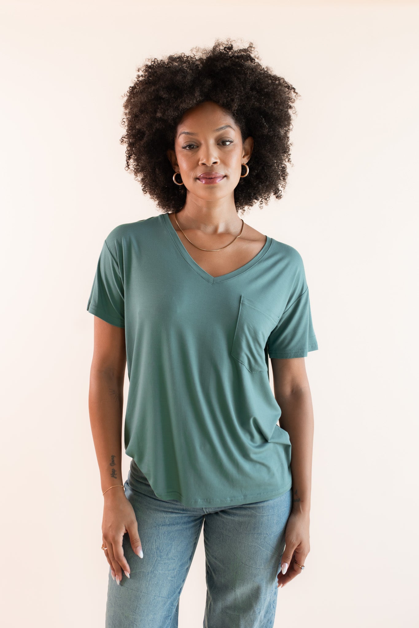 Woman modeling a green v-neck oversized tee
::: Model is 5'9"" wearing size S ///
