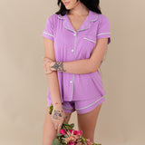 Woman modeling Women’s Short Sleeve Pajama Set in Poi with Cloud Trim holding bouquet of flowers