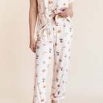 Model showcasing the front side of pajamas of Women's Short Sleeve Cropped Pajama Set in Pumpkin Spice Latte print on a beige background
---1620 3