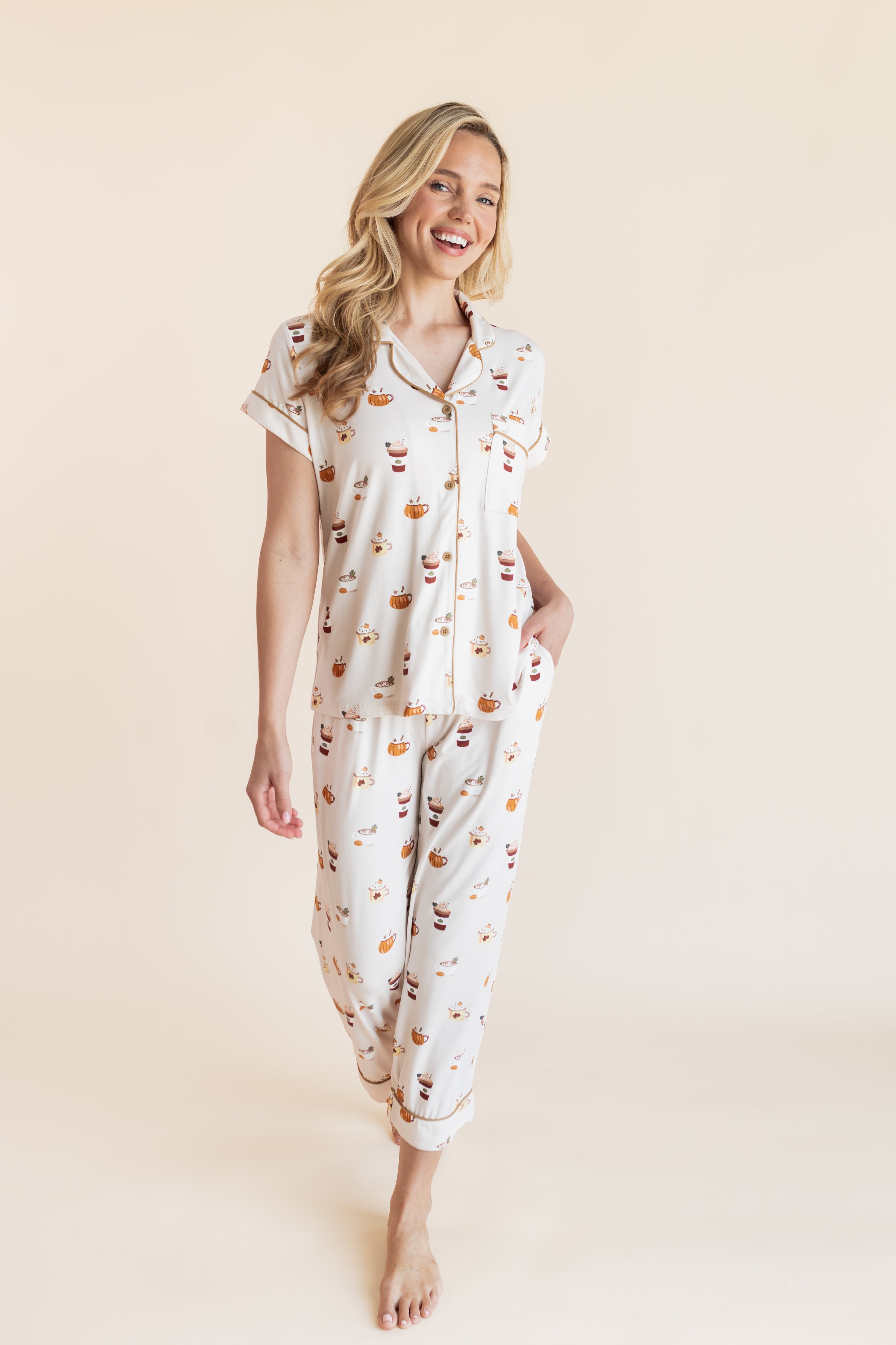 Model posing in Women's Short Sleeve Cropped Pajama Set in Pumpkin Spice Latte print on a beige background
---PJ 4