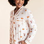 Close up of Model wearing Long-Sleeved Women's Pajama Set in Pumpkin Spice Latte print on a beige background