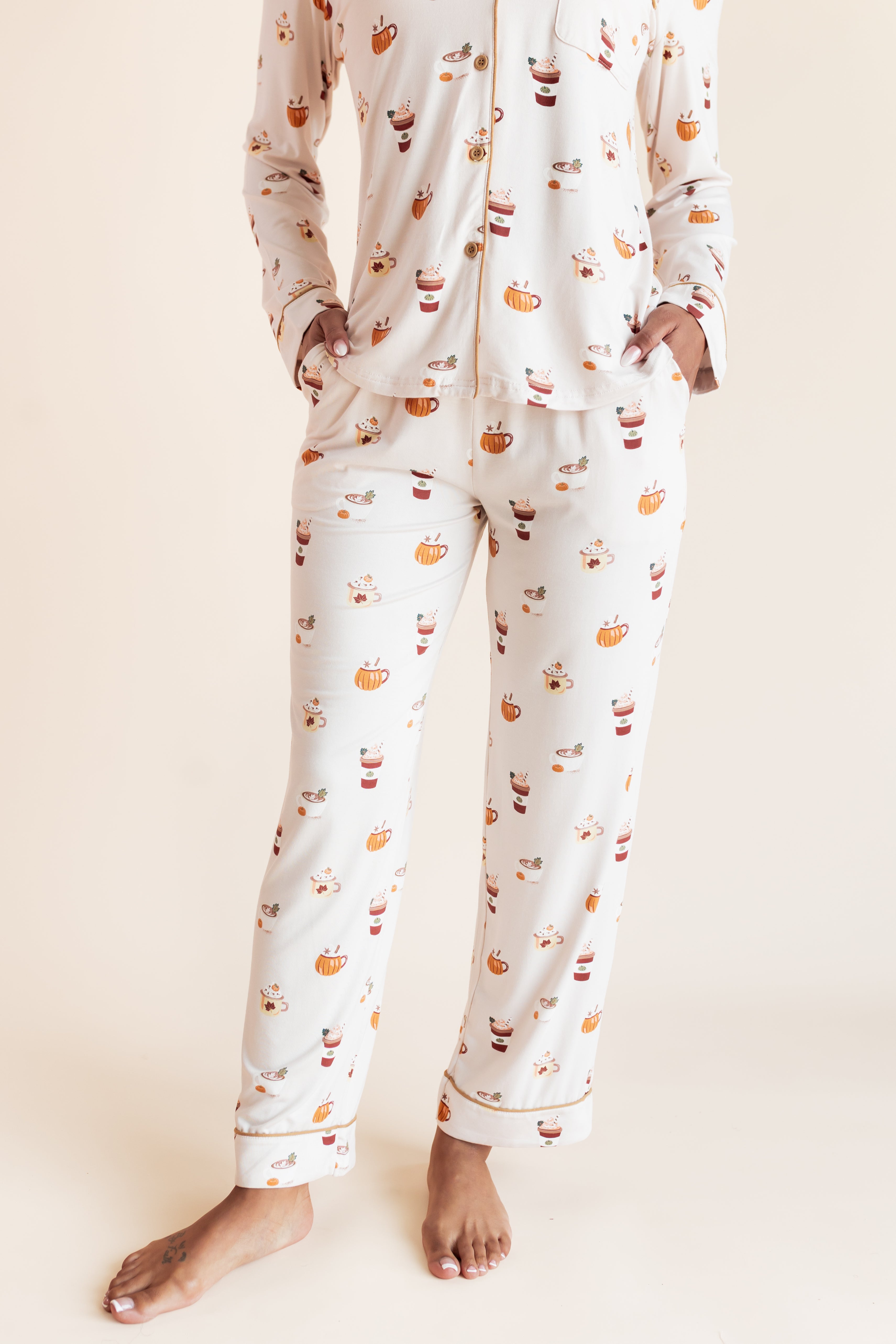 Model showcasing the front side pajamas of Long-Sleeved Women's Pajama Set in Pumpkin Spice Latte print on a beige background
---1605 3