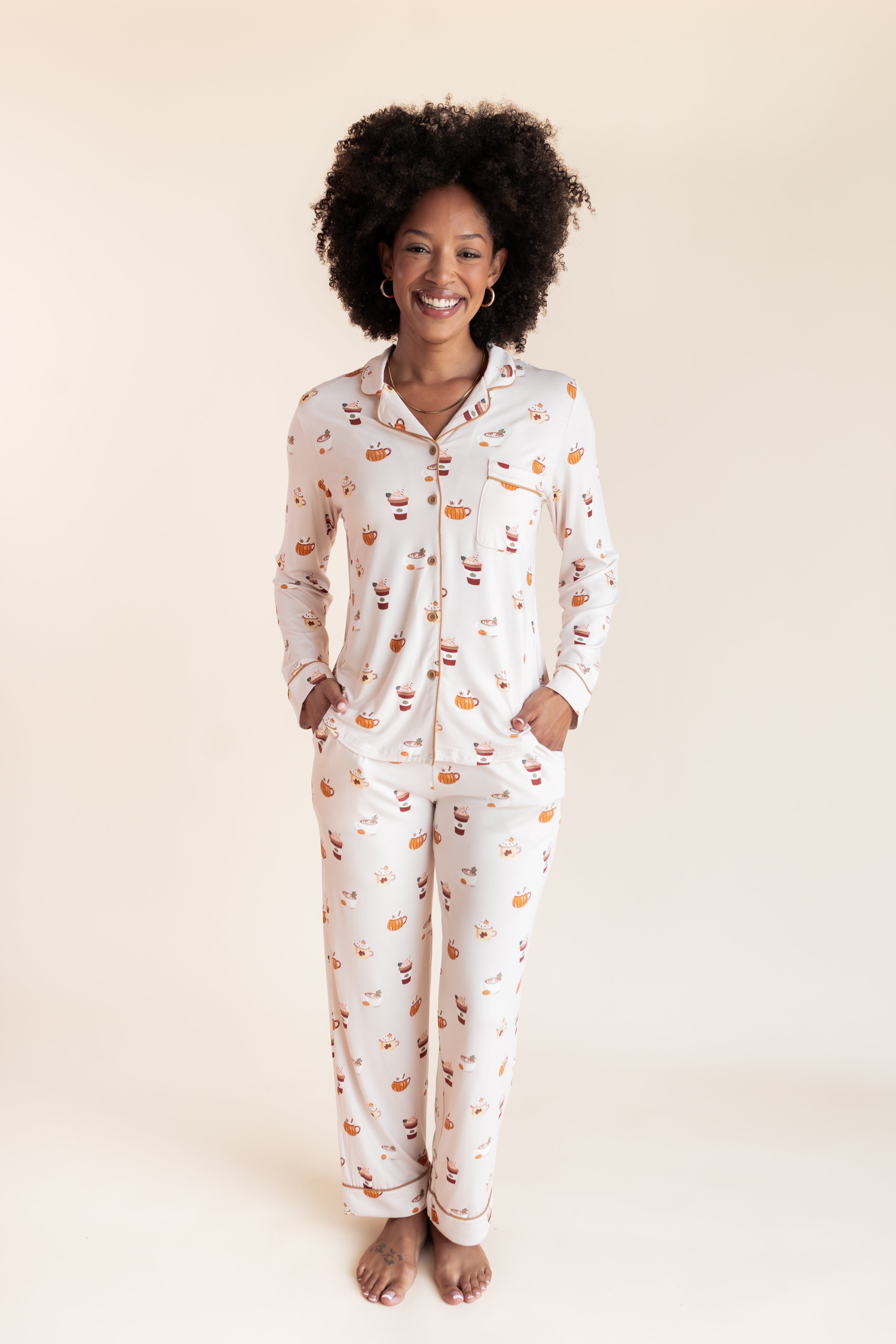 Model smiling in Long-Sleeved Women's Pajama Set in Pumpkin Spice Latte print on a beige background
---PJ 4