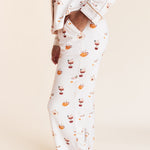 Model showcasing pockets on Long-Sleeved Women's Pajama Set in Pumpkin Spice Latte print on a beige background