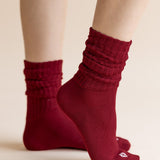 Model wearing Adult Scrunch Socks in Ruby on cream background