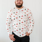 Smiling model wearing the Kyte Men's Long Sleeve Henley Top in Santa Sleigh paired with black jeans