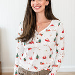 Smiling model wearing the Women's Long Sleeve Henley Tee in Santa Sleigh