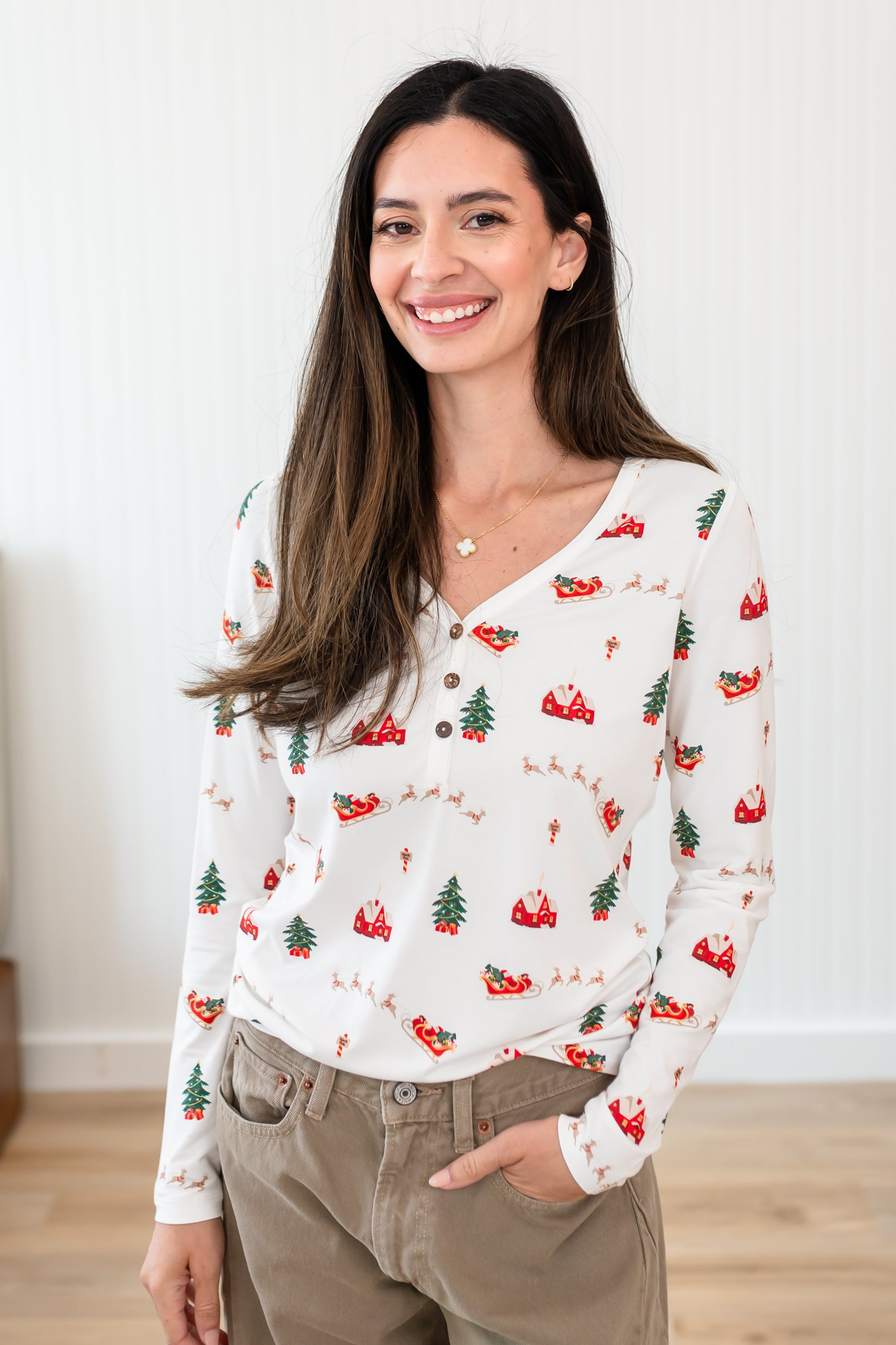Smiling model wearing the Women's Long Sleeve Henley Tee in Santa Sleigh