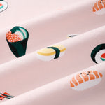 A close-up of a pink fabric with a repeating sushi print, including nigiri, maki, and sashimi motifs in yellow, green, orange, and white.---1615 1