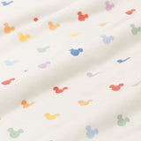 Close up of bamboo fabric swatch: An all-over print of classic Mickey Mouse heads in rows of pastel red, pastel orange, yellow, pastel green, sky blue, a muted blue, and a pinkish lilac, over a warm grey background color called Oat.