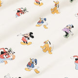 Close up of bamboo fabric swatch: An all-over print featuring: Mickey Mouse in his classic red shorts with white buttons and yellow shoes; Minnie Mouse wearing a blue headbow, a pink dress, and green heels; Goofy jumping in the air and wearing a green hat, a red shirt, blue pants, and orange shoes; Pluto wearing a green collar; and Donald Duck in his classic blue sailor outfit and hat, over a warm grey background color called Oat.