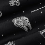 Close up of bamboo fabric: A repeating, monochromatic print featuring: a grey Milennium Falcon; a grey X-wing starfighter; a grey R2-D2; a grey lightsaber; a grey Rebel Alliance starbird symbol; and various grey twinkles and dots, over a black background.