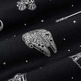 Close up of bamboo fabric: A repeating, monochromatic print featuring: a grey Milennium Falcon; a grey X-wing starfighter; a grey R2-D2; a grey lightsaber; a grey Rebel Alliance starbird symbol; and various grey twinkles and dots, over a black background.