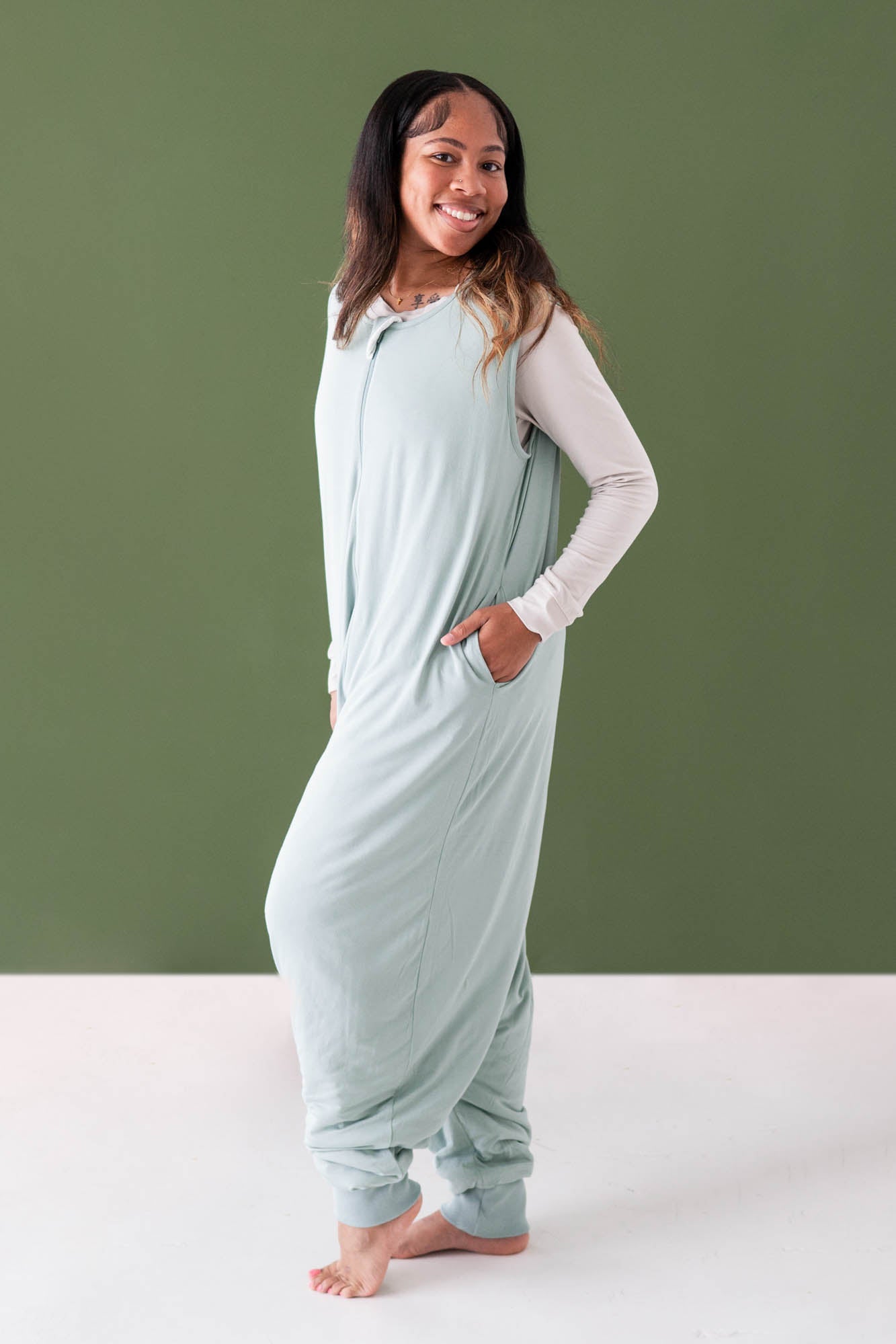 Female modeling the Adult Sleep Bag Walker in Sage with one hand in the pocket