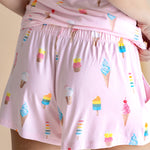 Model showcasing the back of Women's Tank Set shorts in Sakura Ice Cream print on beige background
