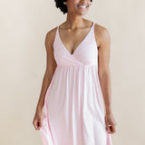 Woman wearing a light pink nightgown dress against a beige background