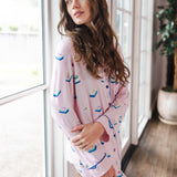 Modal wearing Long-Sleeved Women's Pajama Set in Sakura Mahjong print standing against a window in a living room ---PJ 4