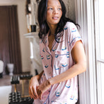 woman wearing pink short sleeve pajama set with mahjong tile print standing against a wall in a living room

---PJ 4

::: Model is 5'10" wearing size S ///