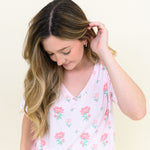Woman modeling Women's Relaxed Fit V-Neck in Sakura Peony looking down towards tee