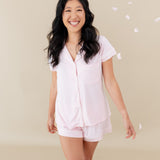 Woman modeling Women’s Short Sleeve Pajama Set in Sakura with Cloud Trim with falling petals