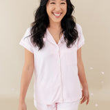 woman modeling Women’s Short Sleeve Pajama Set in Sakura with Cloud Trim with flower petals falling