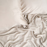 Bamboo Sateen Pillowcase Set in Sand Stone shown on a bed with matching bed sheets
