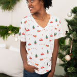 Model looking to the side while wearing the Women's Relaxed Fit V-Neck in Santa Sleigh paired with dark jeans