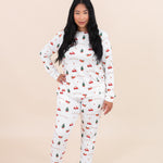 Smiling model wearing the Kyte Women's Jogger Pajama Set in Santa Sleigh
