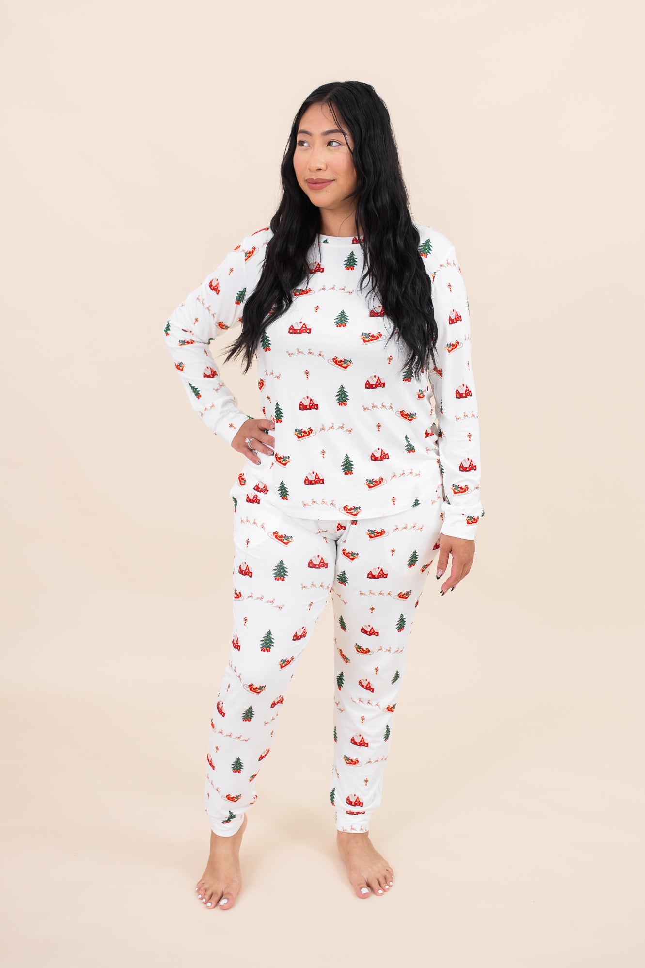 Woman looking to the side while modeling the Kyte Women's Jogger Pajama Set in Santa Sleigh