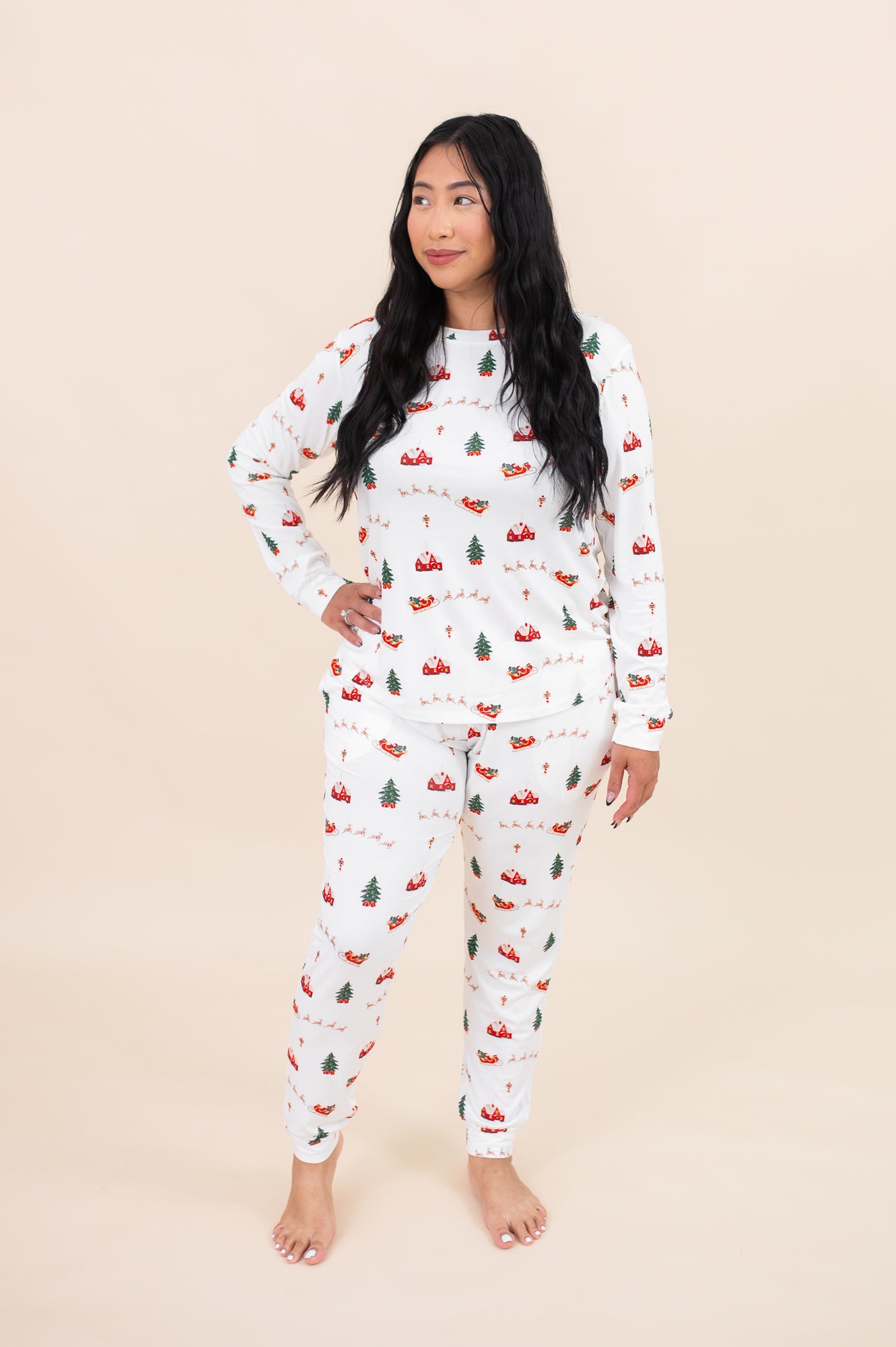 Woman looking to the side while modeling the Kyte Women's Jogger Pajama Set in Santa Sleigh