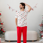 Model wearing the Men's Crew Neck Tee in Santa Sleigh with one arm on his head and Lounge Pants in Cardinal